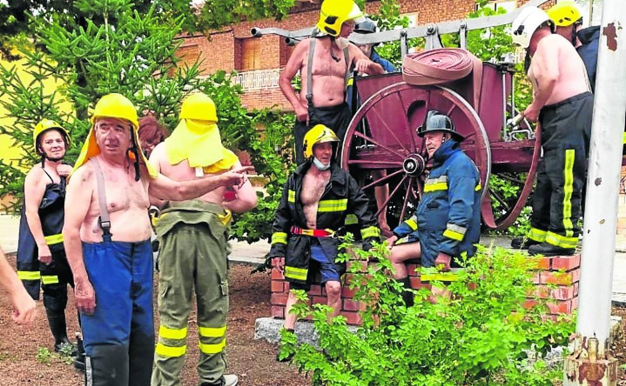 Un grupo de vecinos posan para el calendario solidario junto a la antigua bomba contraincendios. 