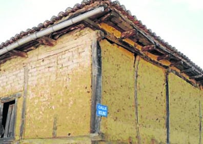 Imagen secundaria 1 - Arriba, puente sobre el río Carrión que facilita el paso de los vecinos hacia la localidad; construcciones en adobe y una de las casas rehabilitada en el municipio. 