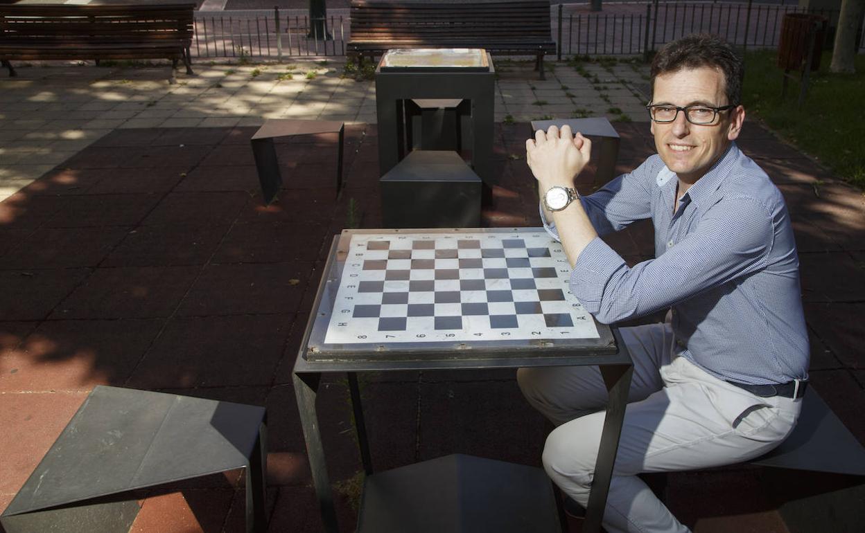 Pedro Herrero posa junto a la mesa de ajedrez de la plaza de San Juan, en Valladolid. 