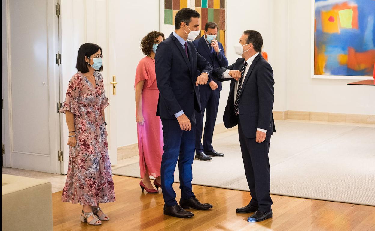 El presidente del Gobierno, Pedro Sánchez, y el de la FEMP, Abel Caballero, se saludan antes de firmar el acuerdo. 