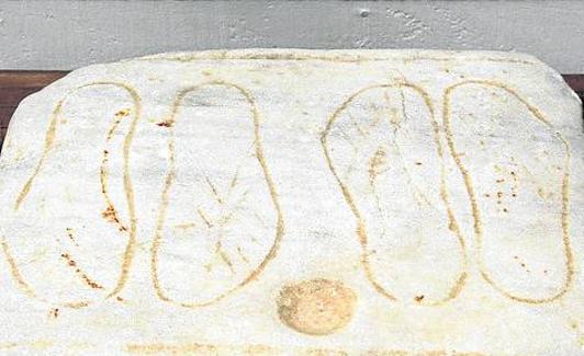 Exvoto de mármol con sandalias dibujadas.