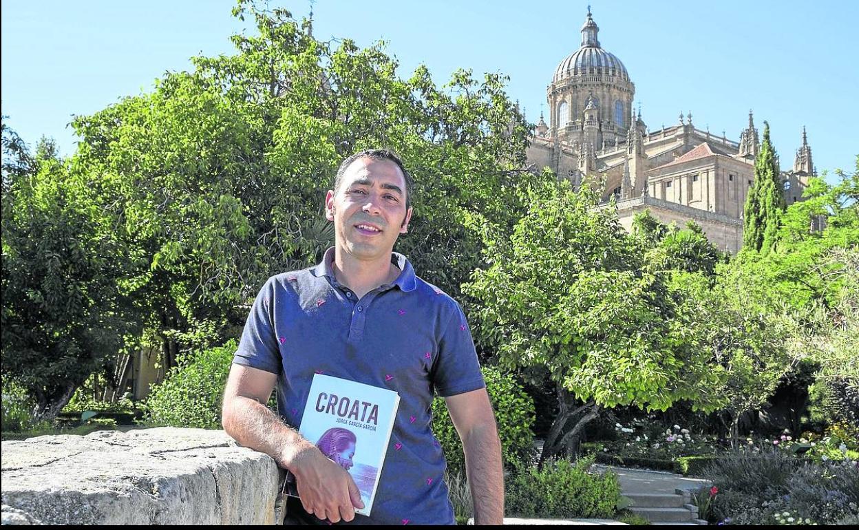 Jorge García posa con su novela 'Croata' con la Catedral al fondo. 