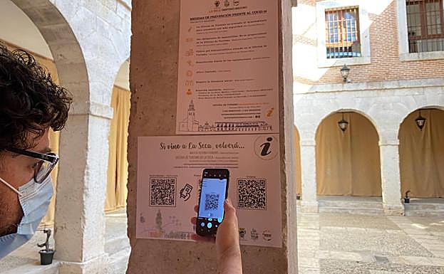 Un joven se descarga información de La Seca en su móvil con un código QR.