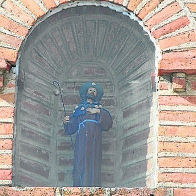 Imagen de Santiago peregrino sobre el arco de entrada de la puerta de la iglesia parroquial.