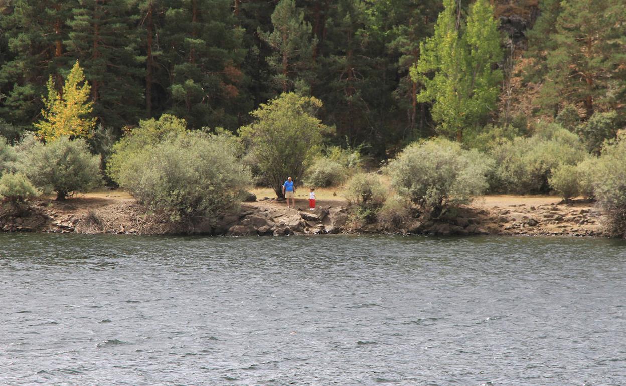 Senderistas en un lado del pantano de Puente Alta, en Revenga, este lunes. 