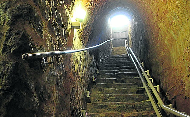 Imagen principal - En la parrte superio, bajada a una bodega mucenteña; prensa vertical en el Museo del Vino y camino de piedra entre varias bodegas.