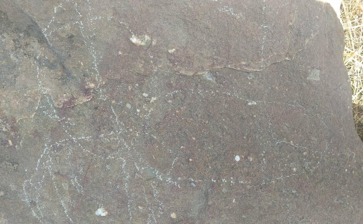 Rayan y pintan una de las losas que cubre el corredor del dolmen neolítico de Bernardos