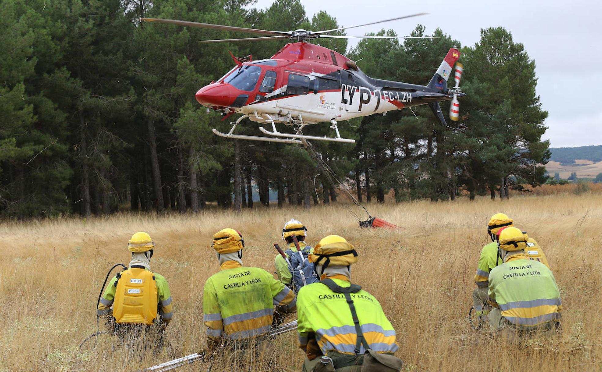 Efectivos de la base se agachan durante el despegue del helicóptero. 