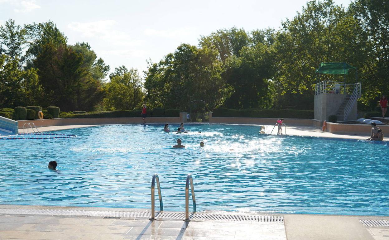 Varios bañistas disfrutan de unos minutos de descanso y relajación en la piscina de La Aldehuela. 