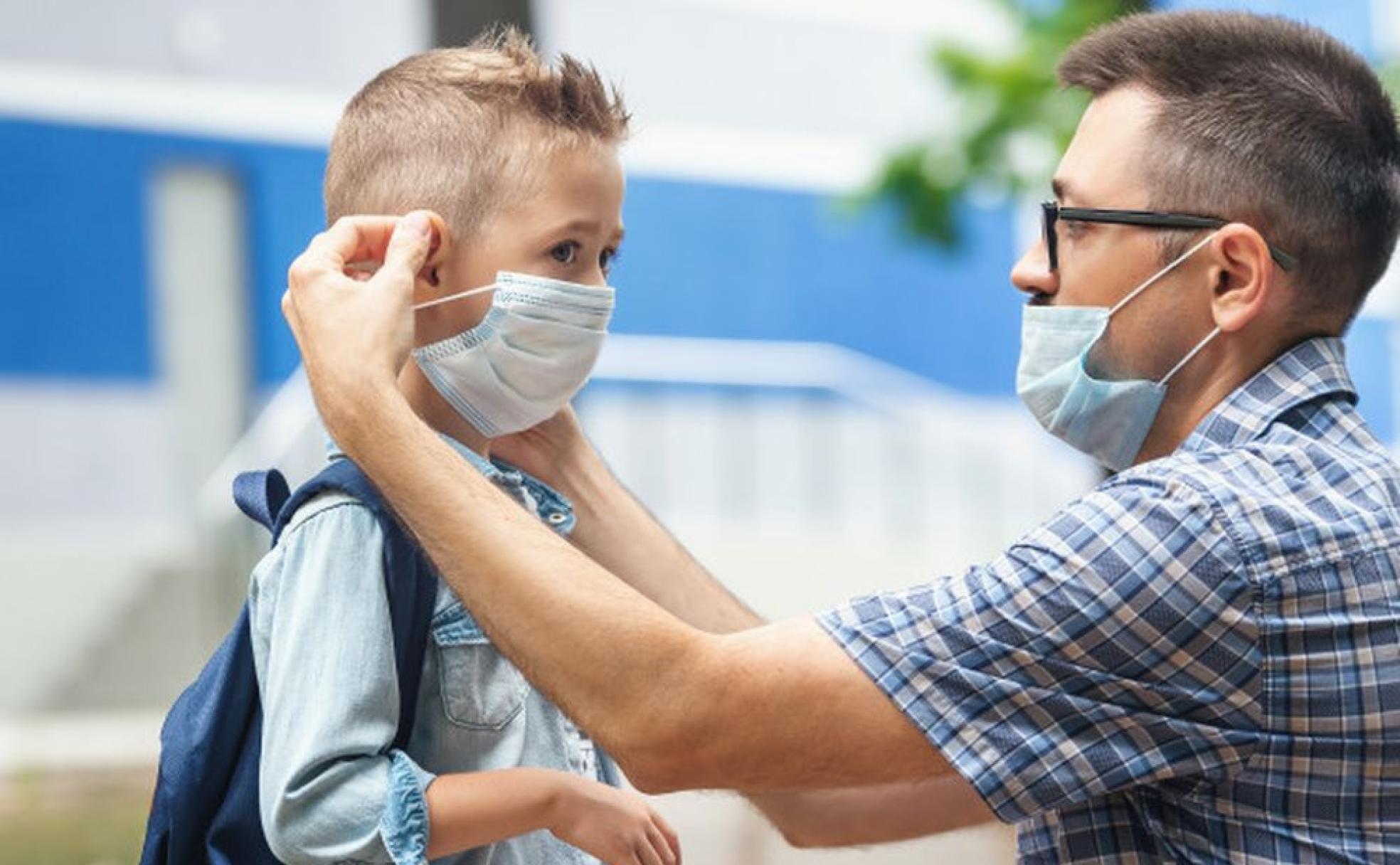 Un padre coloca la mascarilla a su hijo en una imagen de archivo.