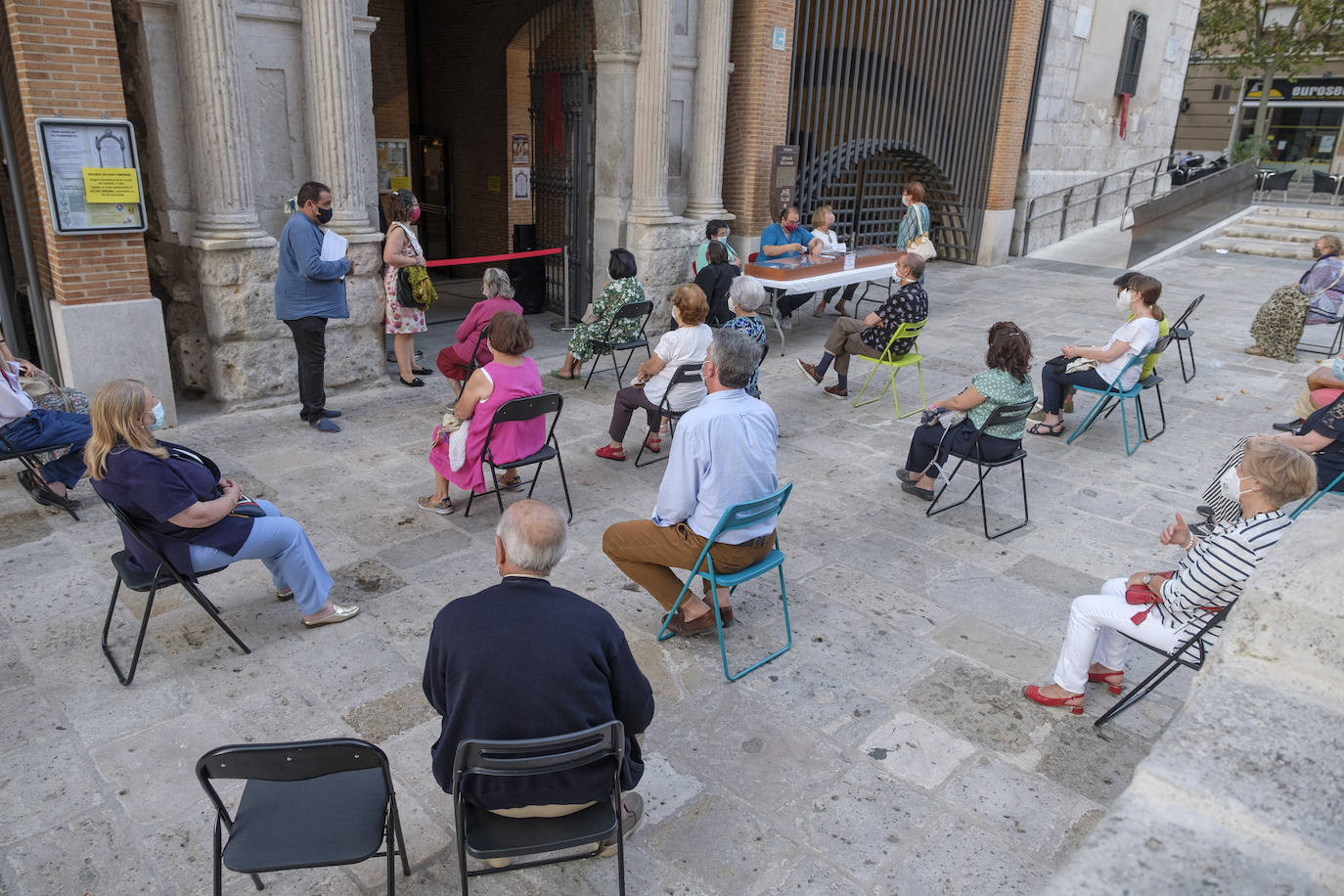 Hay sillas negras, azules y verdes, esparcidas por el empedrado suelo del acceso a la iglesia de San Lorenzo, en la calle Pedro Niño | Y allí, sentados, en la calle y con la vista en el interior del templo, un grupo de fieles sige la celebración