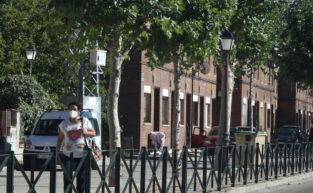 Una mujer camina por una calle de Coca. De Torre