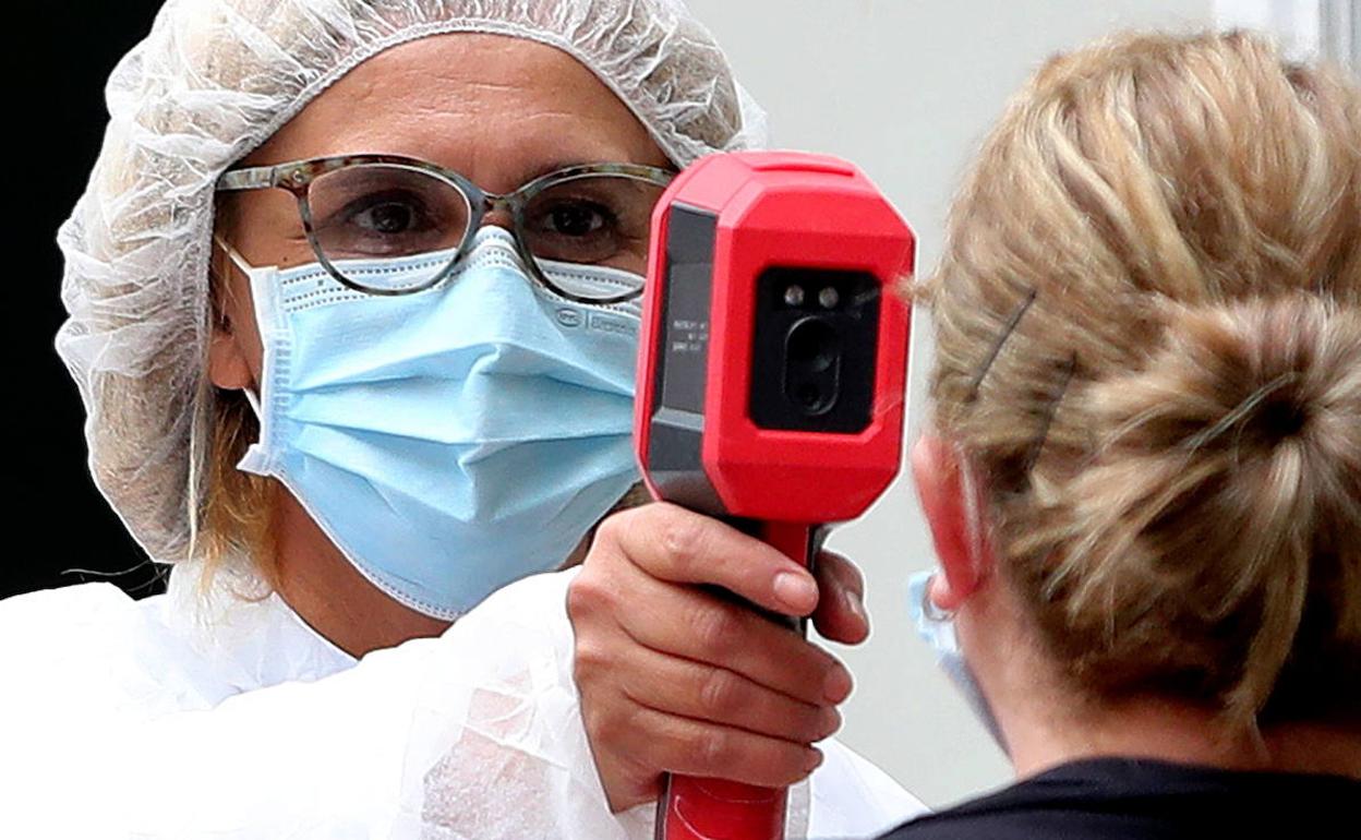 Una sanitaria toma la temperatura a una paciente.