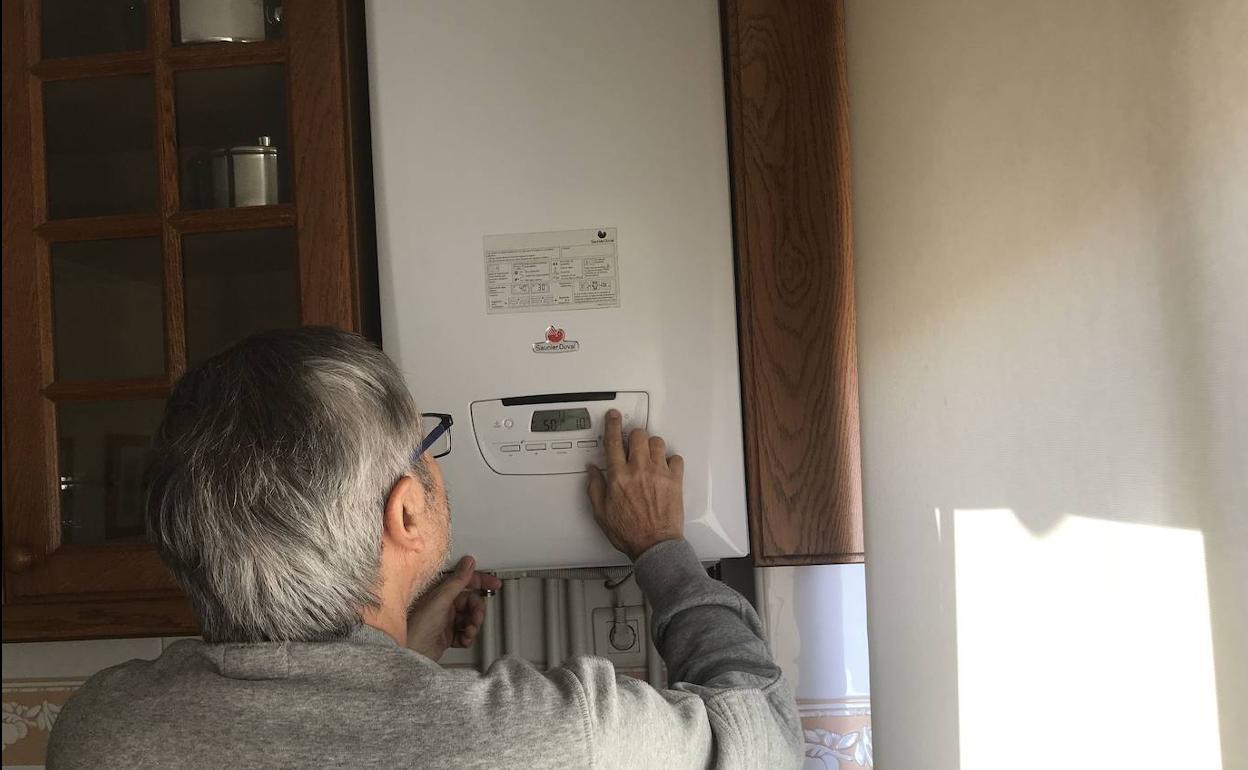 Un hombre revisa su caldera.