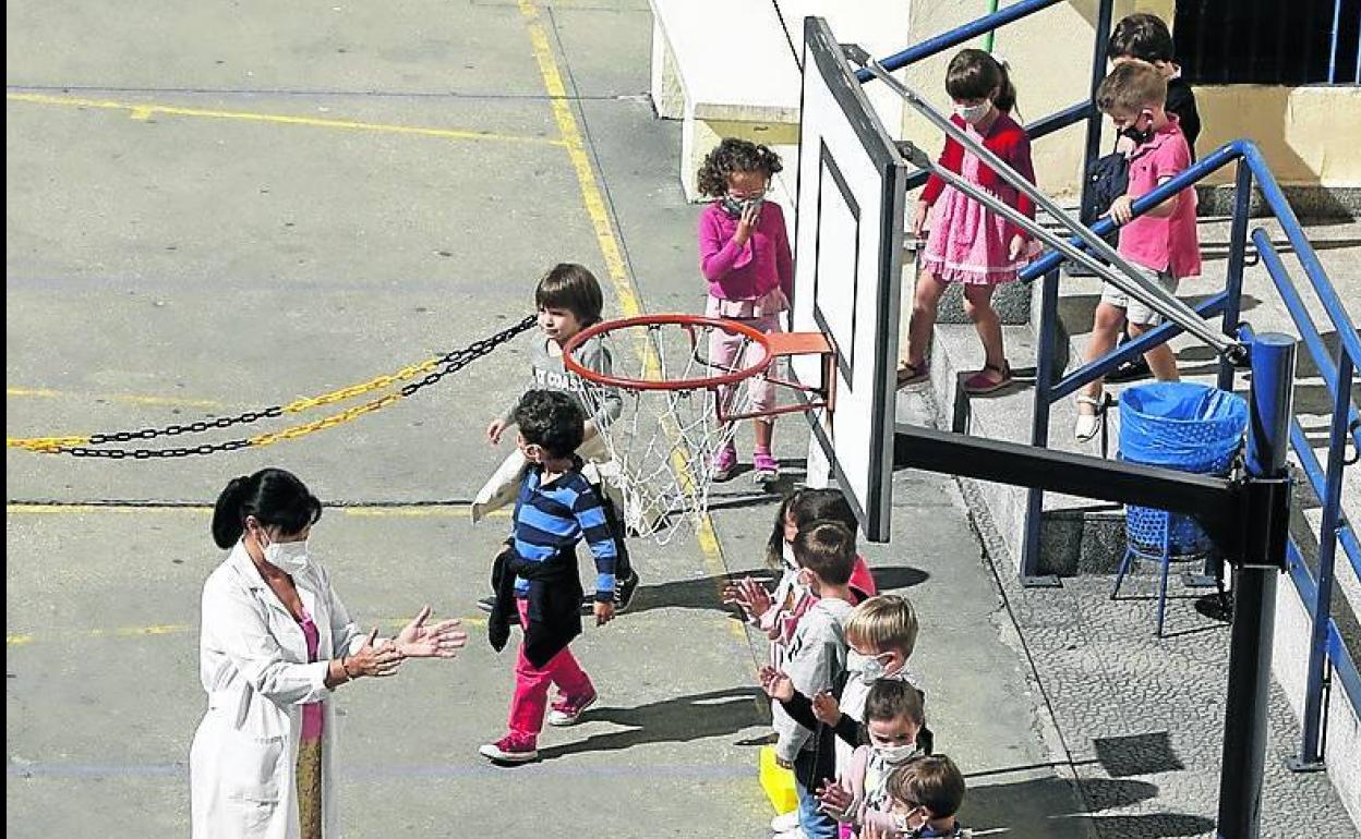 Una profesora enseña a limpiarse las manos a los niños.