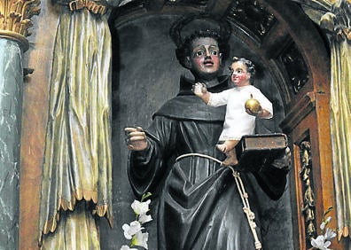 Imagen secundaria 1 - Arriba, Piedad, en uno de los laterales de la Iglesia de San Juan Evangelista; abajo, estatua de San Antonio y San Isidro.