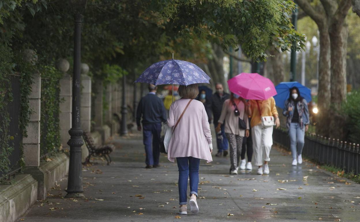 Un grupo de personas pasean por Valladolid en un día de lluvia.
