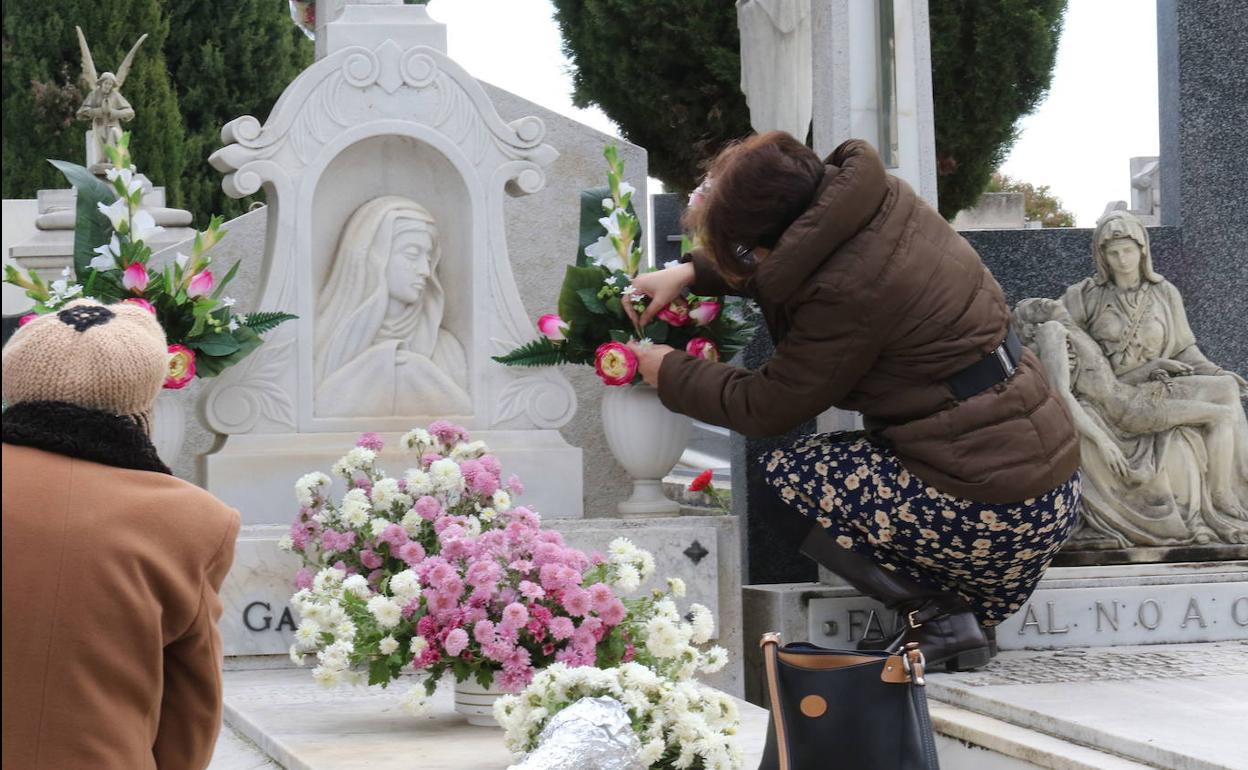 Una mujer coloca flores en una sepultura en el Dia de Todos los Santos en el Cementerio de Carmen el año pasado.