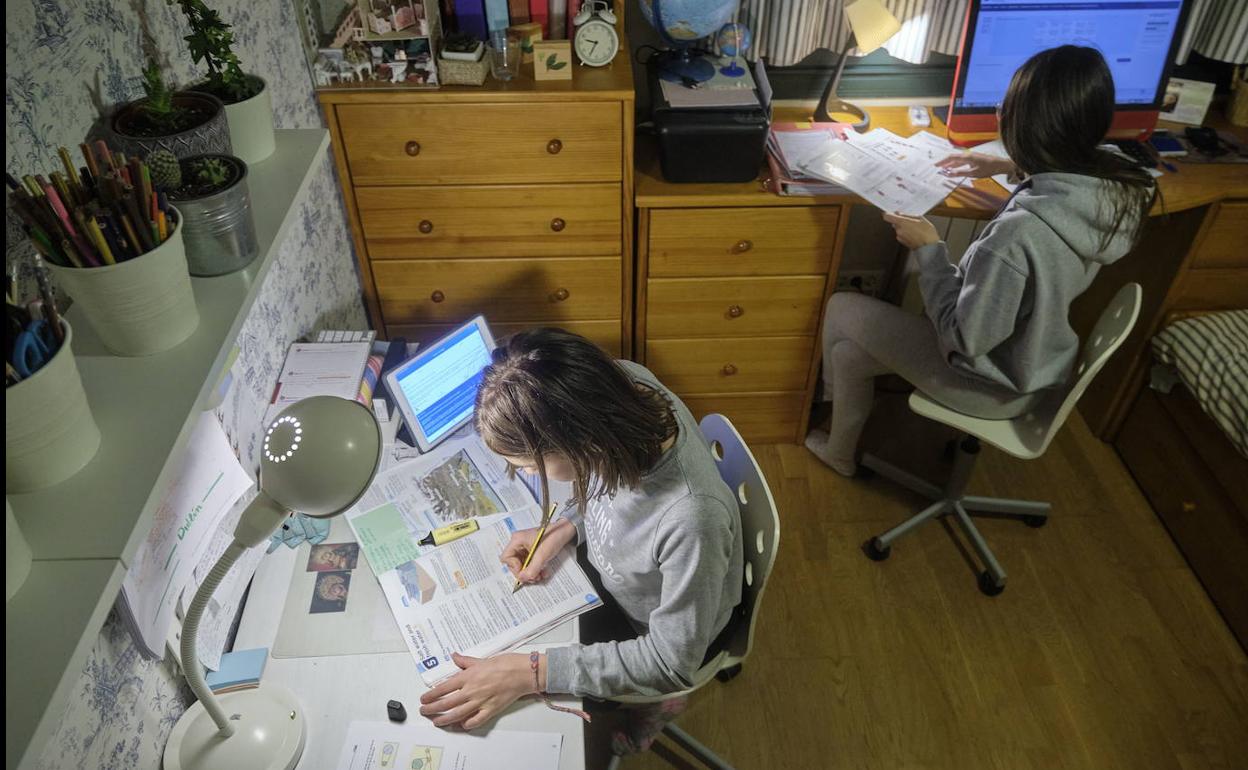 Dos niñas estudian durante el confinamiento por la pandemia del coronavirus