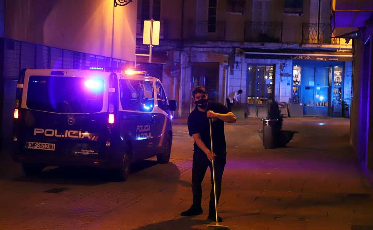 Un hostelero recoge la terraza de una bar durante el toque de queda.