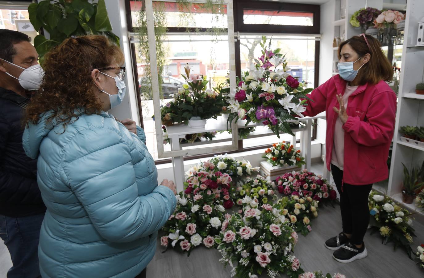 Unos clientes se interesan por los centros de la floristería Pétalos.