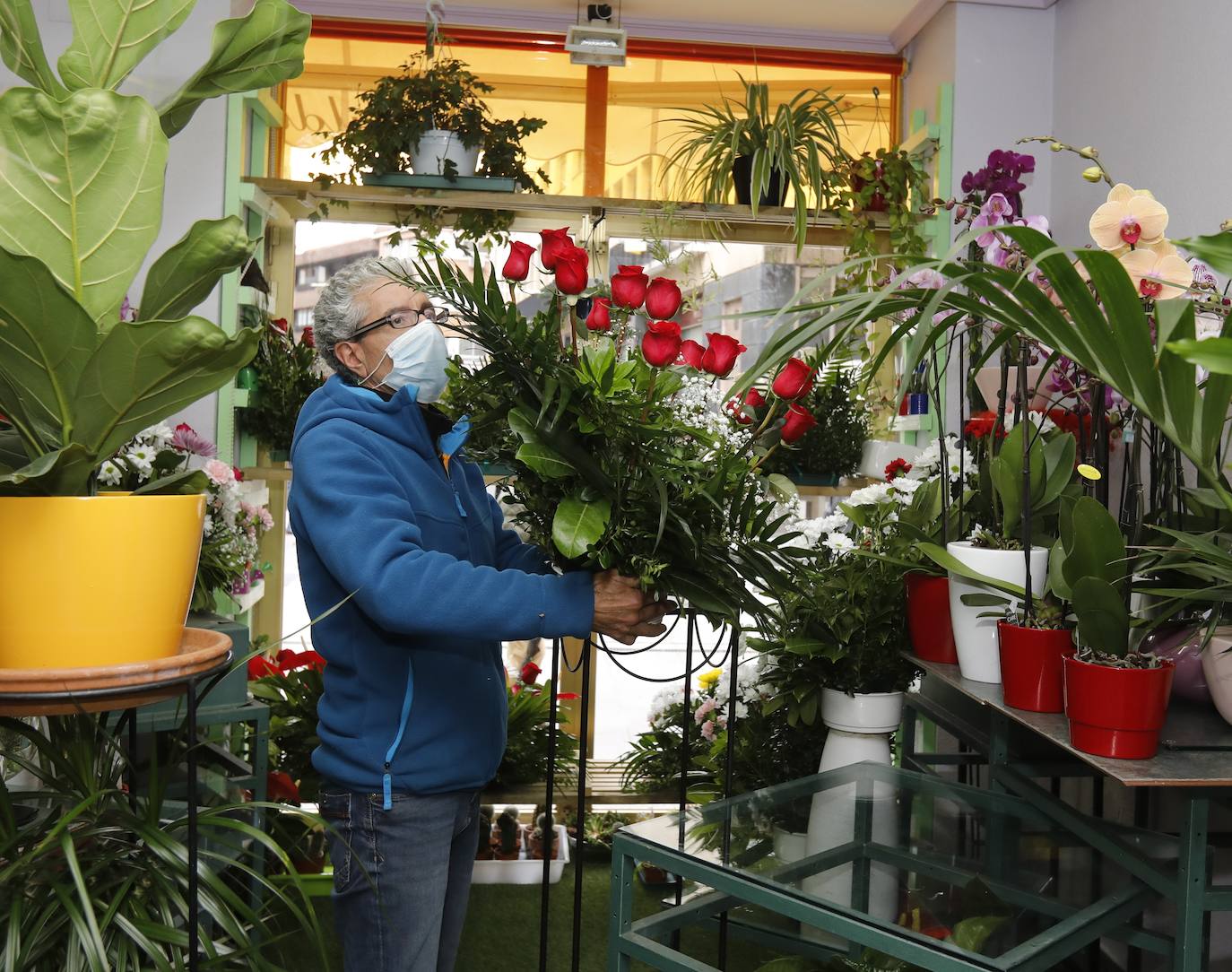 El propietario coloca el nuevo escaparate de la floristería Vivaldi.