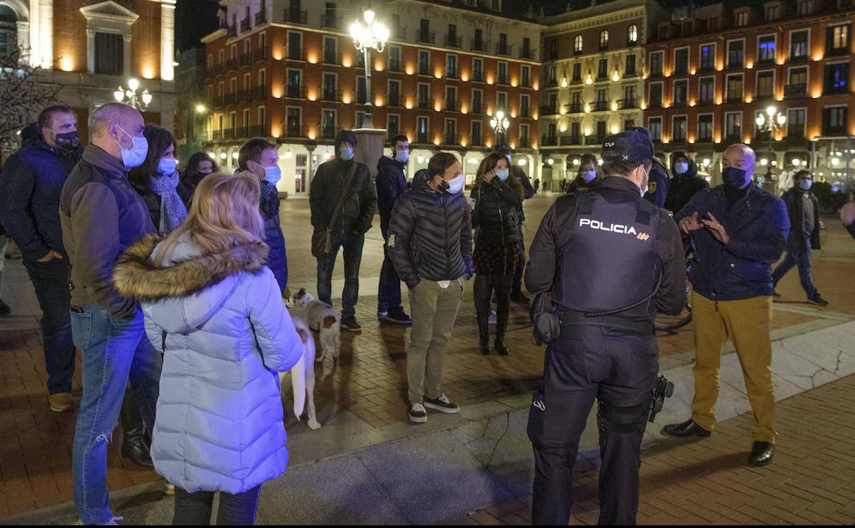 Agentes de la Policía Nacional identifican a una veintena de personas que protestaban contra el toque de queda pasadas las 22:00 del pasado sábado. 