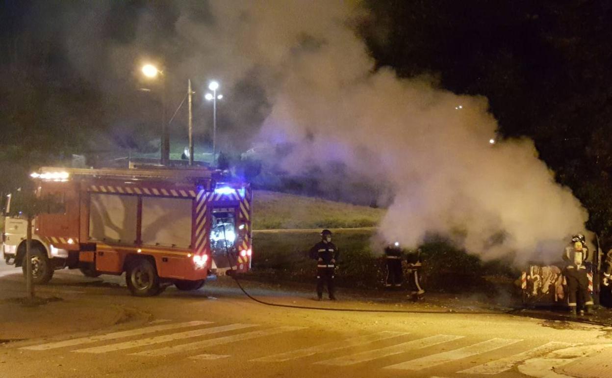 Los Bomberos de Burgos trabajan para extinguir las llamas en un contenedor quemado en San Isidro.