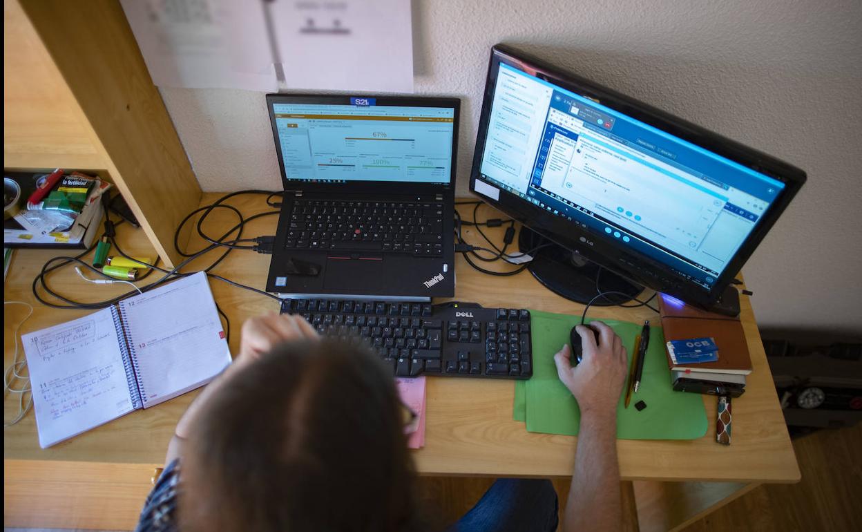 Una persona teletrabaja con un portátil desde su casa. 