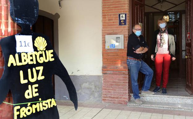 Imagen principal - Anita Steenstra y Gabriel Martínez reciben a la puerta del albergue Luz de Frómista. Camas para los peregrinos y tienda de artesanía.