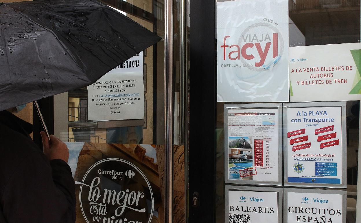 Un cliente se para junto a la puerta de una agencia de viajes de la ciudad.