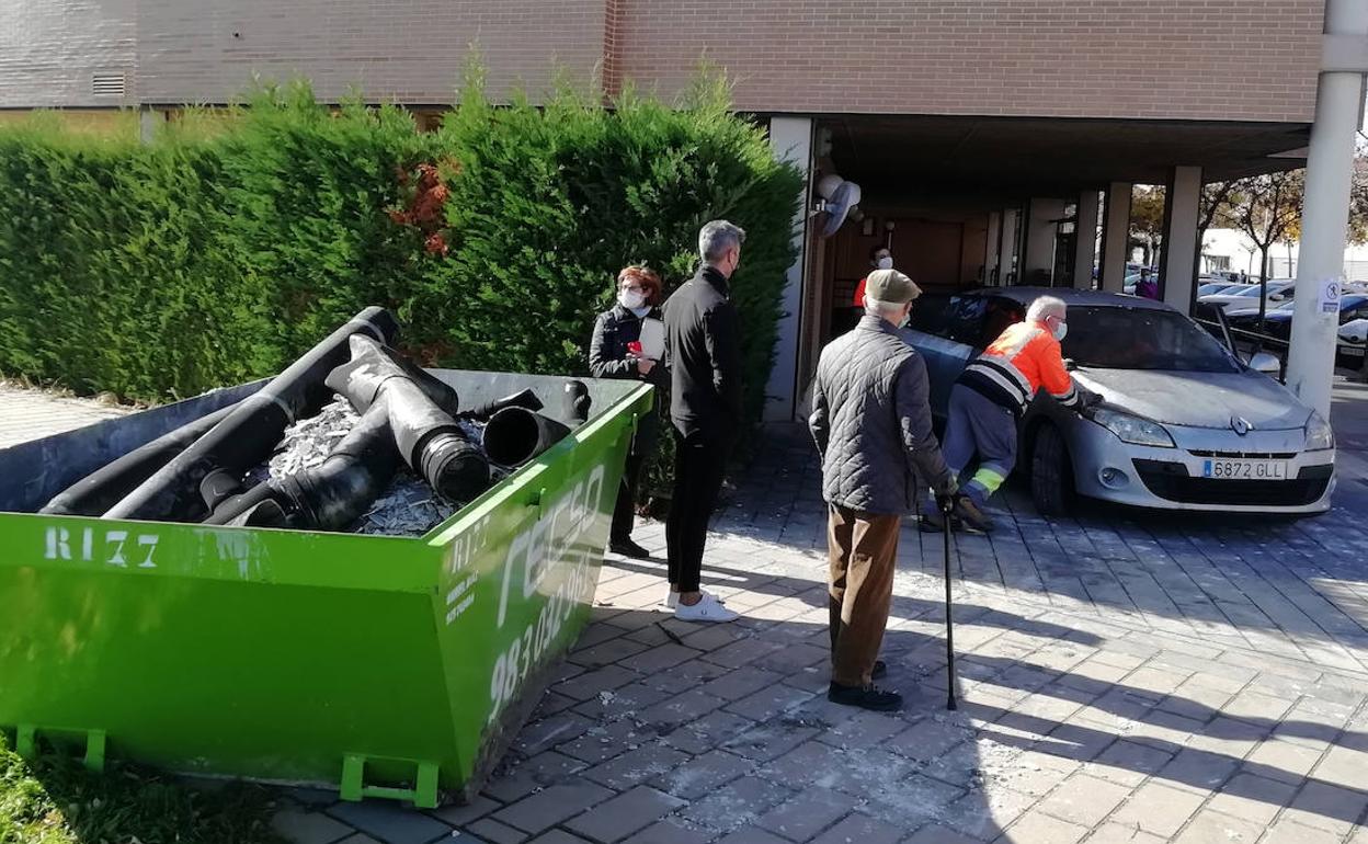 Los vecinos asisten a la retirada de los vehículos y al desescombro del garaje incendiado en la calle Felipe Sánchez Román.
