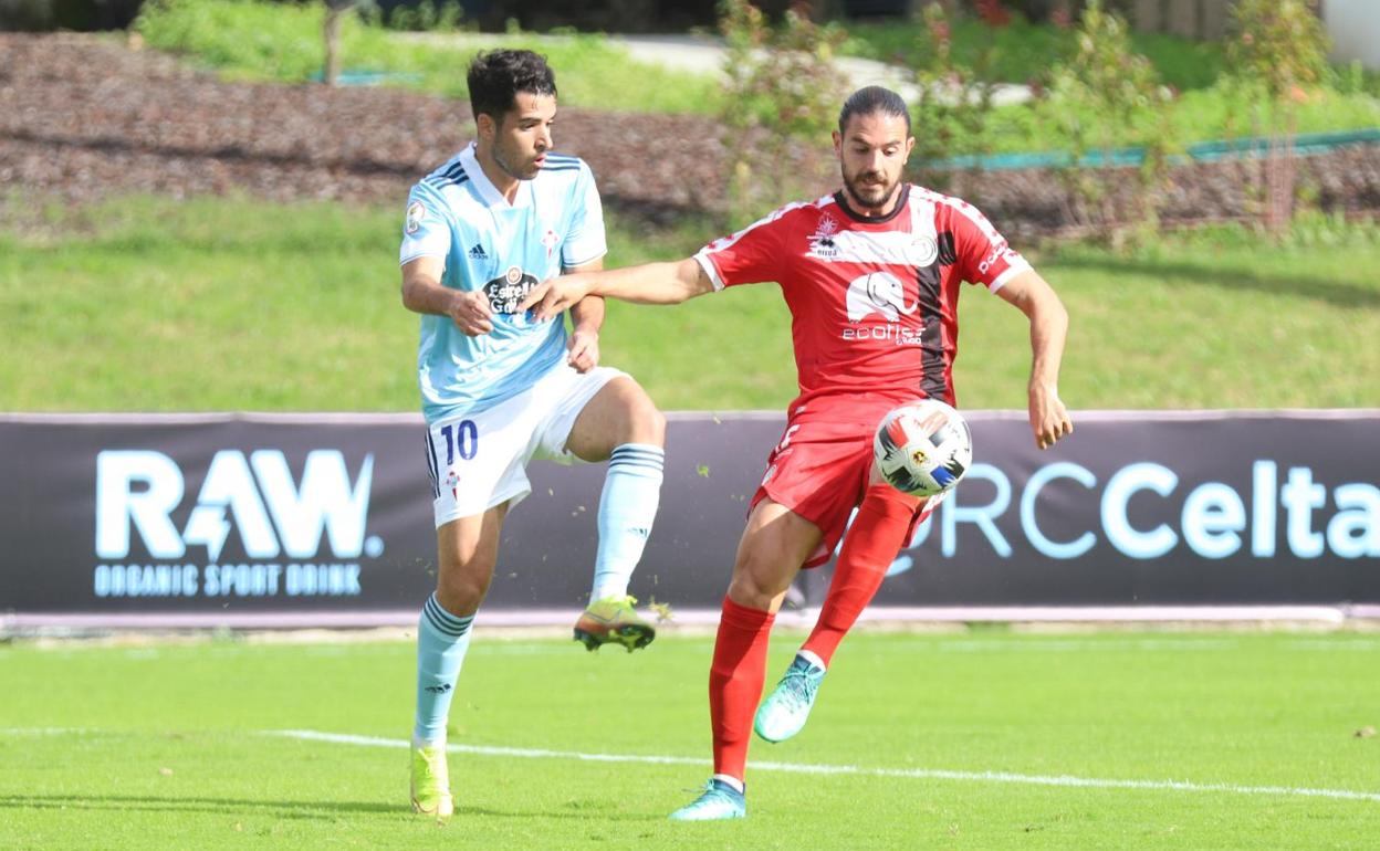 Mario Gómez se lleva el balón presionado por un rival del Celta B. 