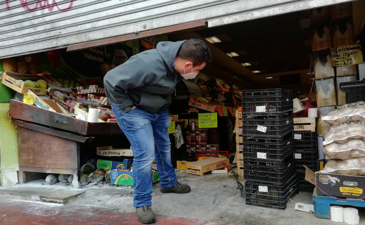 Borja examina la entrada de la frutería incendiada el lunes en la avenida de Segovia.