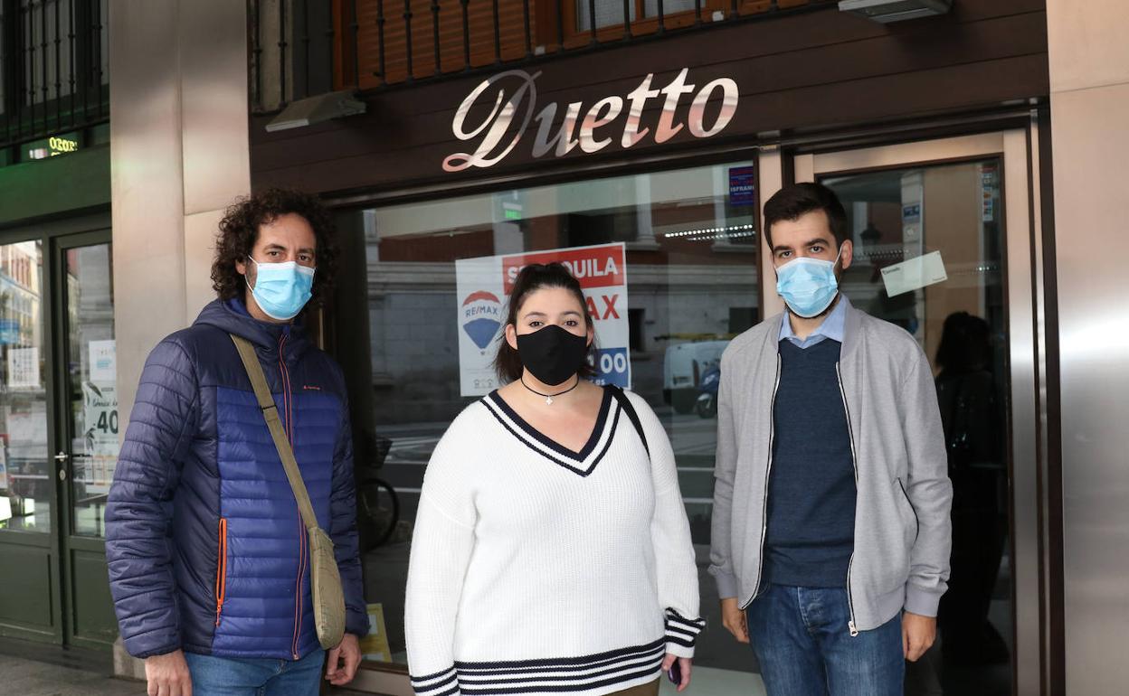 Tres de los afectados frente al escaparate de la tienda.