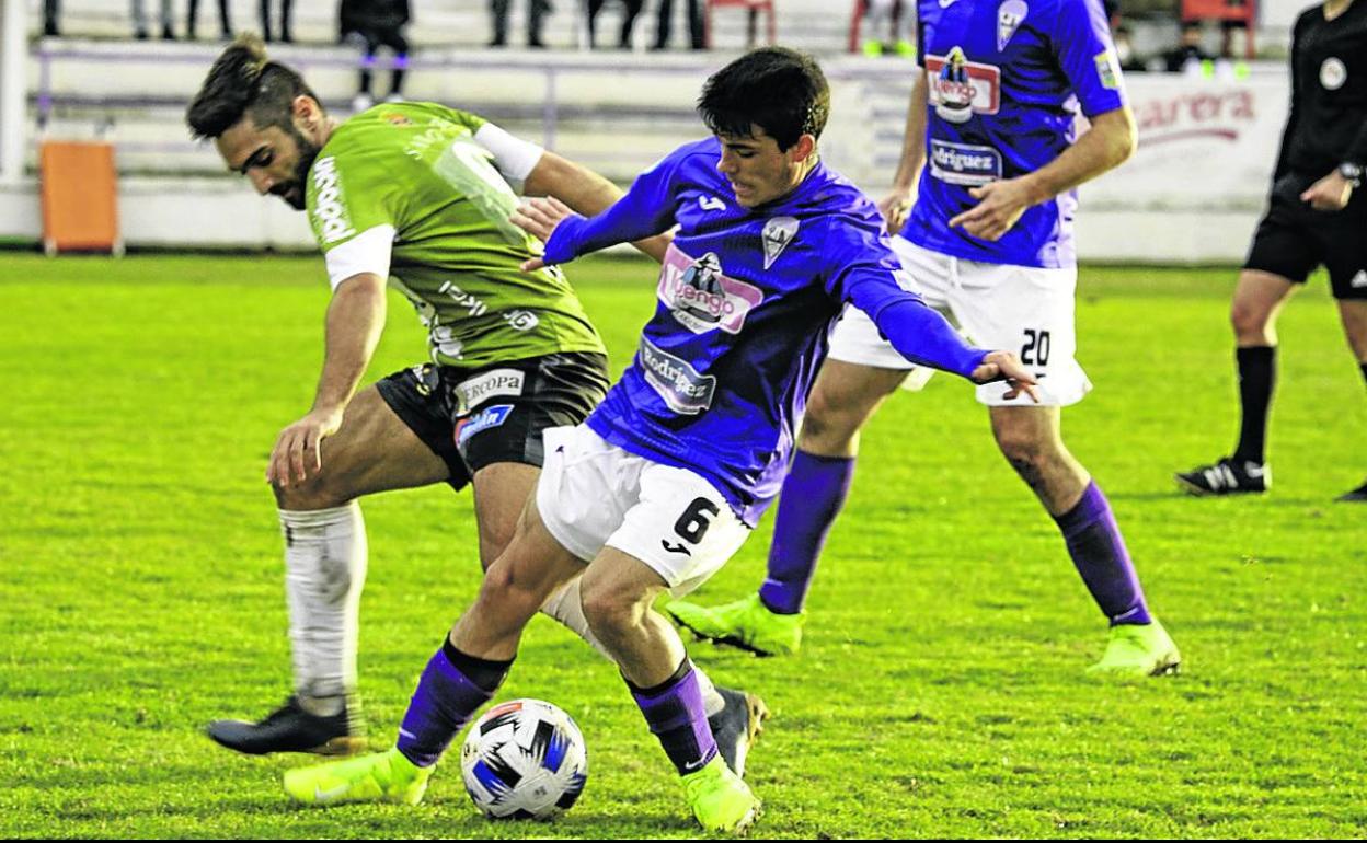 Jesús Torres, en un balón dividido con un adversario. 