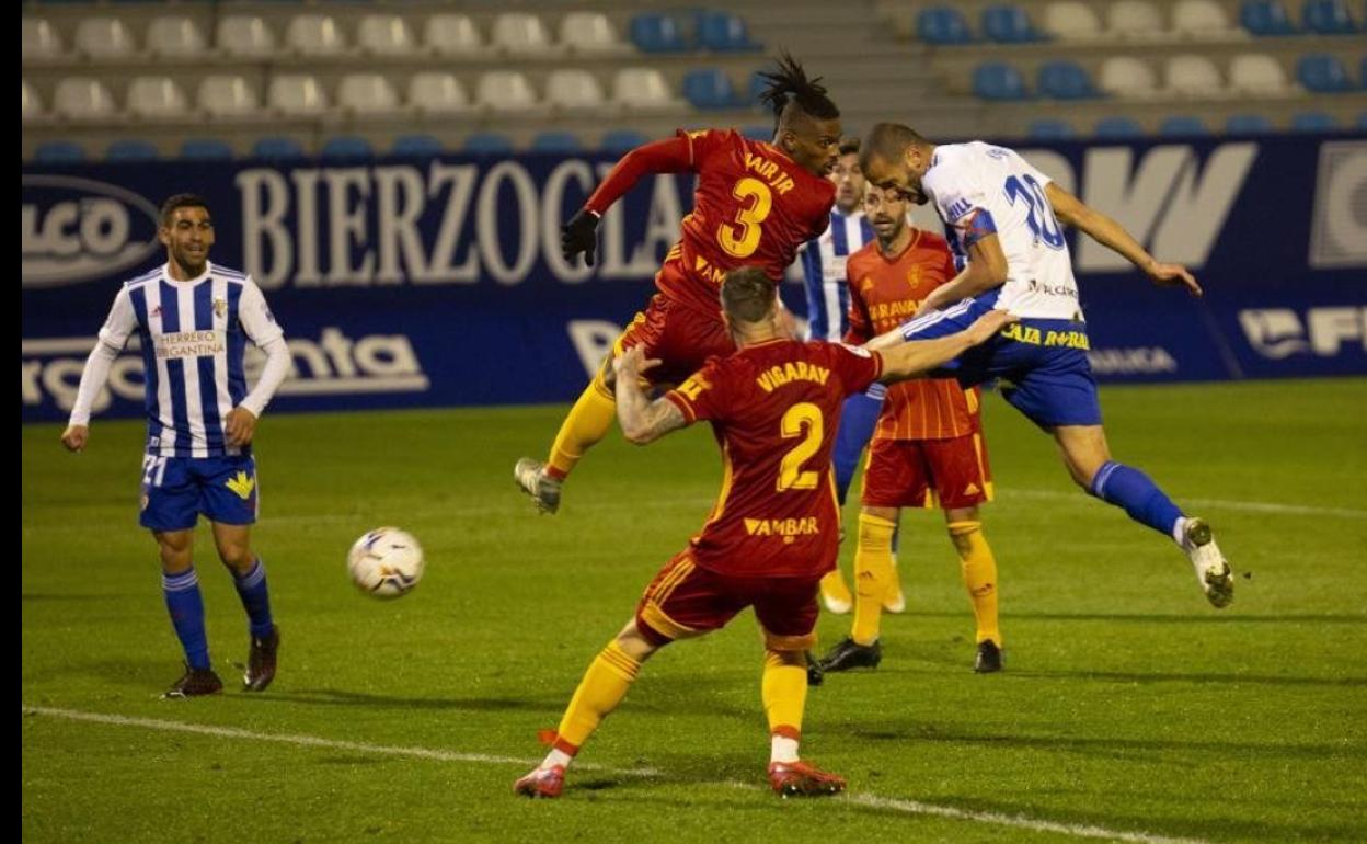 Dos jugadores pugnan en un balón aéreo en una de las últimas acciones del partido en El Toralín. 