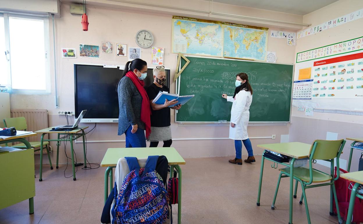 La directora del colegio intercambia opiniones con dos trabajadoras del centro. 