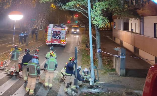 Los Bomberos trabajan en el asegurado de la farola contra la que impactó el vehículo del fallecido. 