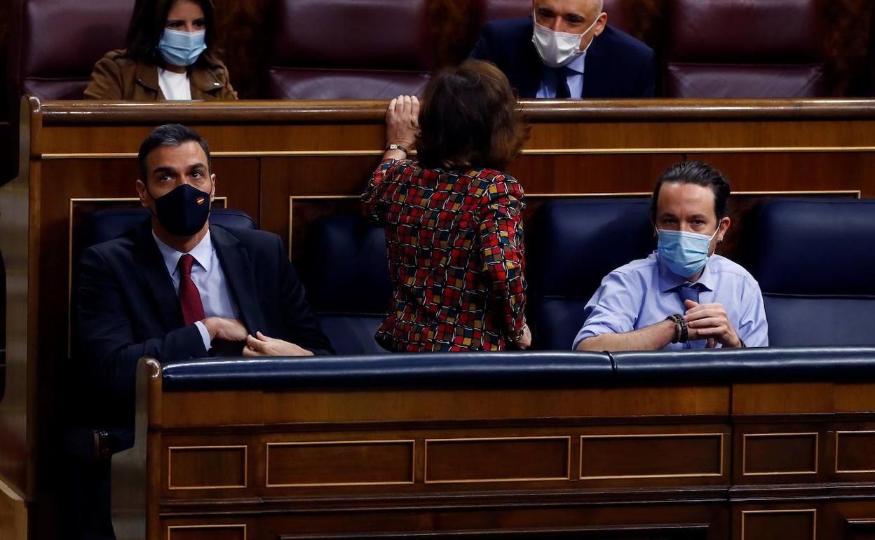 Pedro Sánchez y Pablo Iglesias con Carmen Calvo de espaldas.