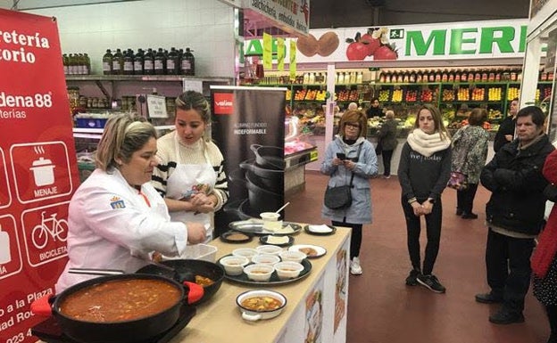 Leticia Martín cocinando en el mercado junto a la concejal Laura Vicente.