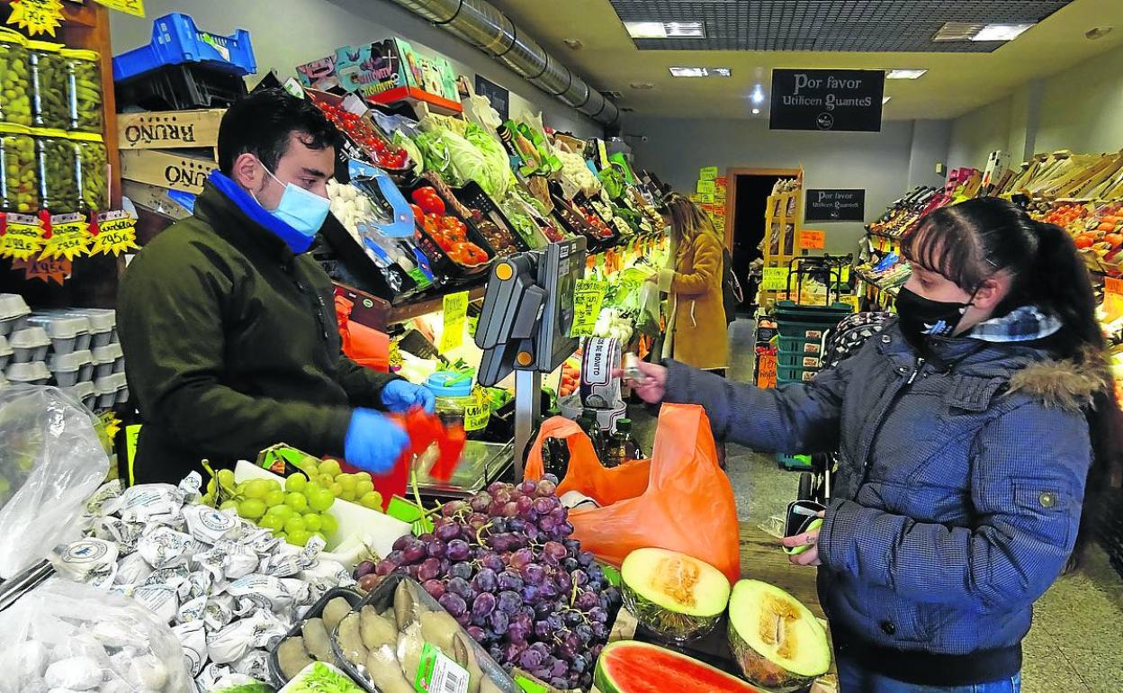 Borja, el frutero de la avenida de Segovia, atiende a una mujer en su negocio. 