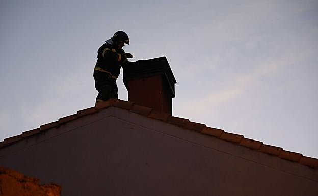 Un bombero comprueba la chimenea de la vivienda de Pesquera de Duero. 