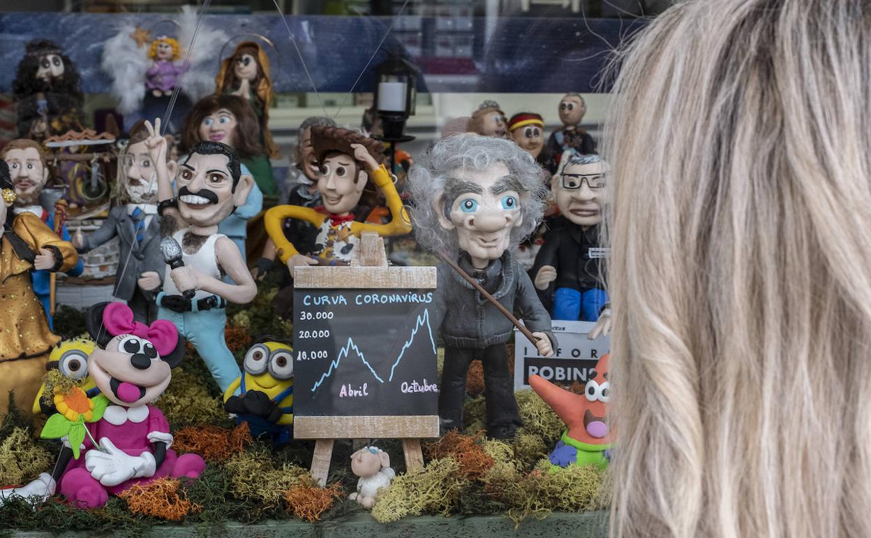 Una mujer contempla el belén de la farmacia de la calle Torrecilla, con Fernando Simón entre sus figuras. 