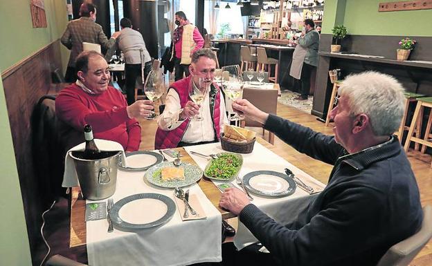 Tres comensales brindan en una mesa del restaurante Las Aldabas. 