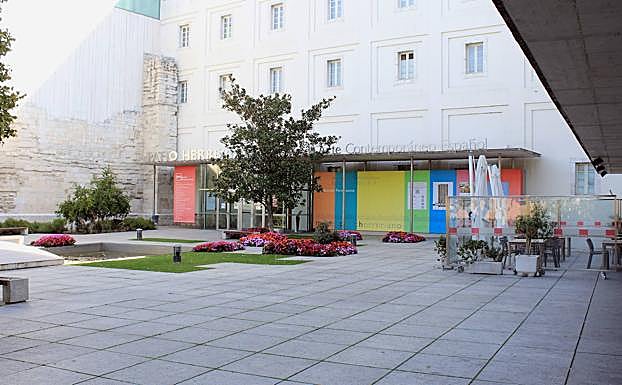 Vista del jardín y el estanque que presiden la entrada del museo, y las mesas del restaurante ubicado en la plaza de acceso.