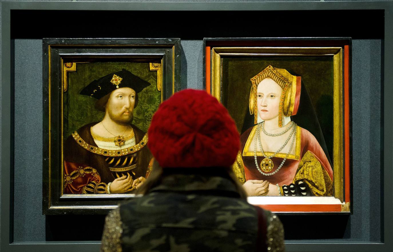 Una mujer contempla los retratos de Enrique VIII y Catalina de Aragón. 