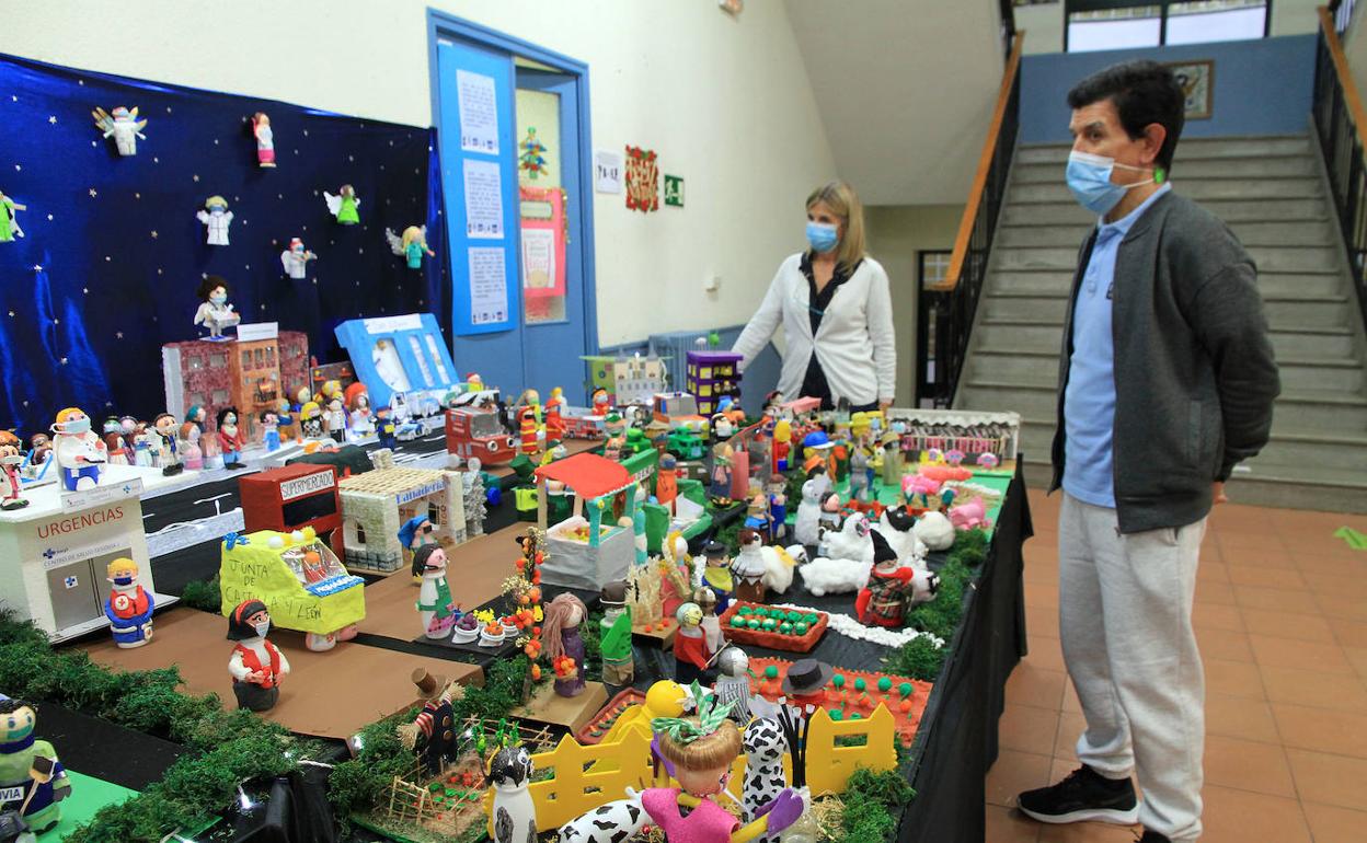 El director del colegio observa el belén elaborado por alumnos y profesores. 