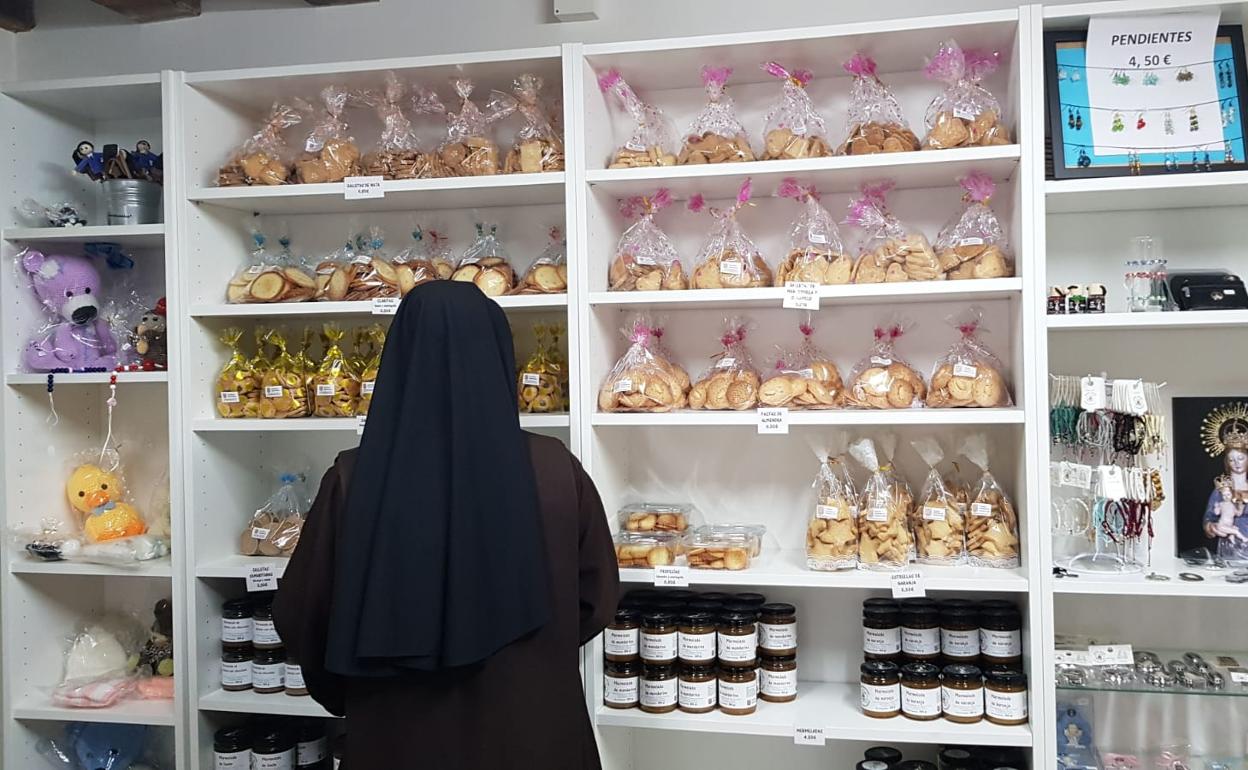 Una religiosa observa los productos a la venta en el santuario.