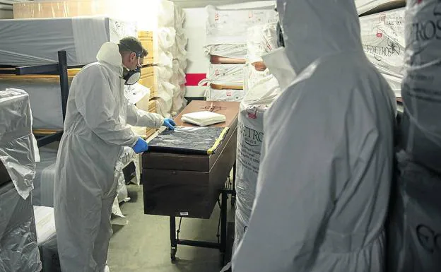 Trabajadores de la funeraria preparan un sudario especial para un enfermo de covid que acaba de fallecer, antes de salir para el Hospital General a recoger el cuerpo. 